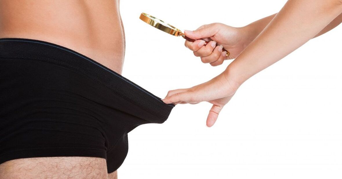 Seorang gadis melihat melalui kaca pembesar pada penis kecil